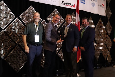 Jeff Miller, left, from Hendrickson, watches as Lucas Deal, editor of Trucks, Parts, Service, presents Mark Hall, general manager of Stoops Trailers with the Trailblazer Award. At right is Bennett Whitnell, vice president of sales at Procede Software. Procede and Hendrickson sponsor the award.