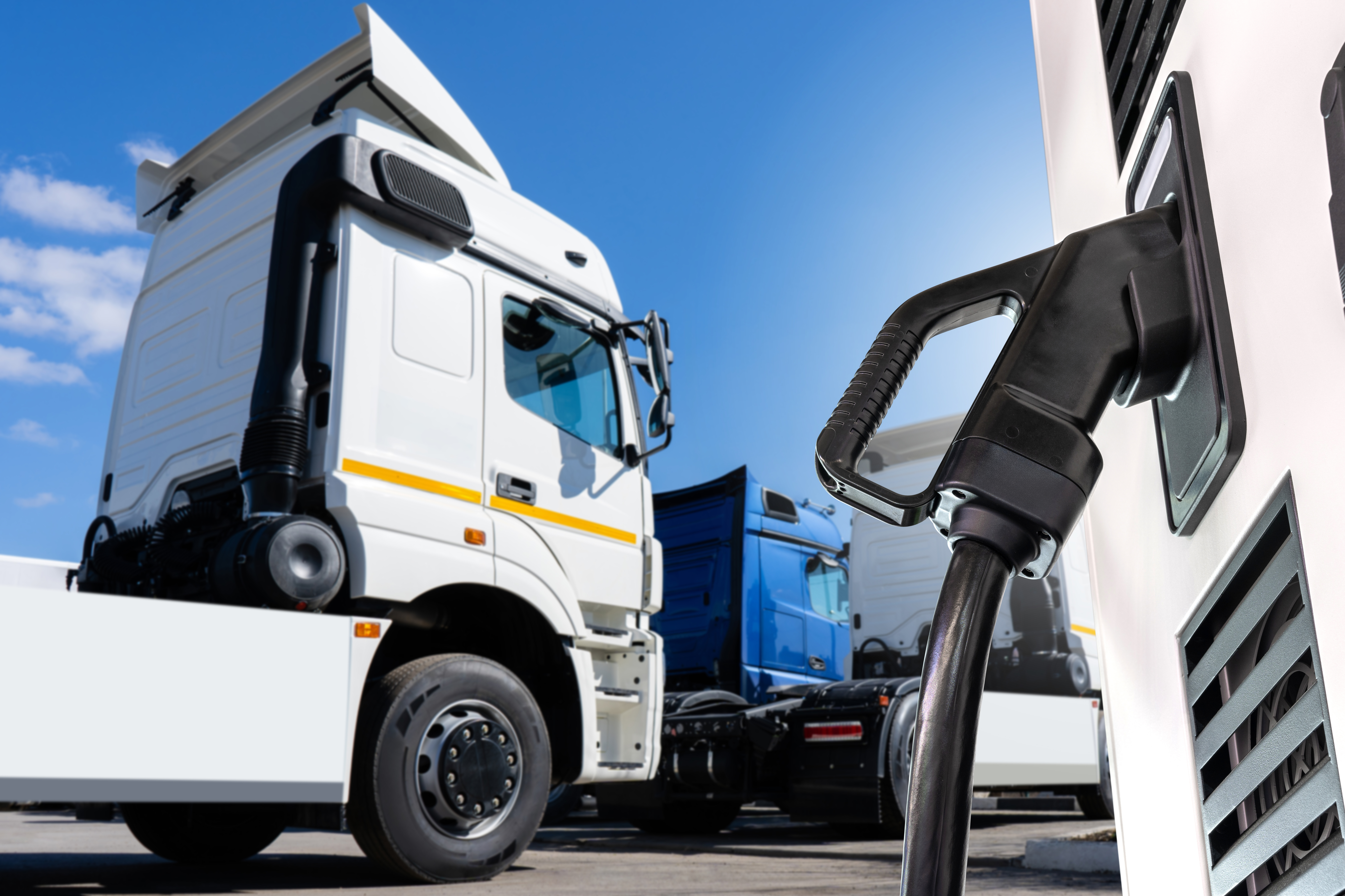 A white semi truck awaits refueling at a truck depot.