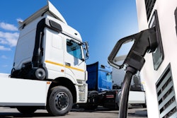 A white semi truck awaits refueling at a truck depot.