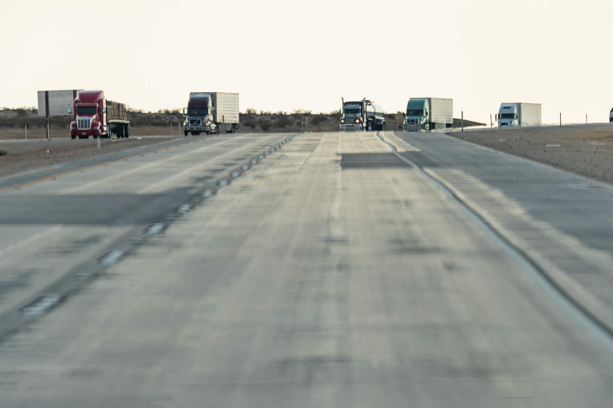 Trucks On Highway With Pavement In View