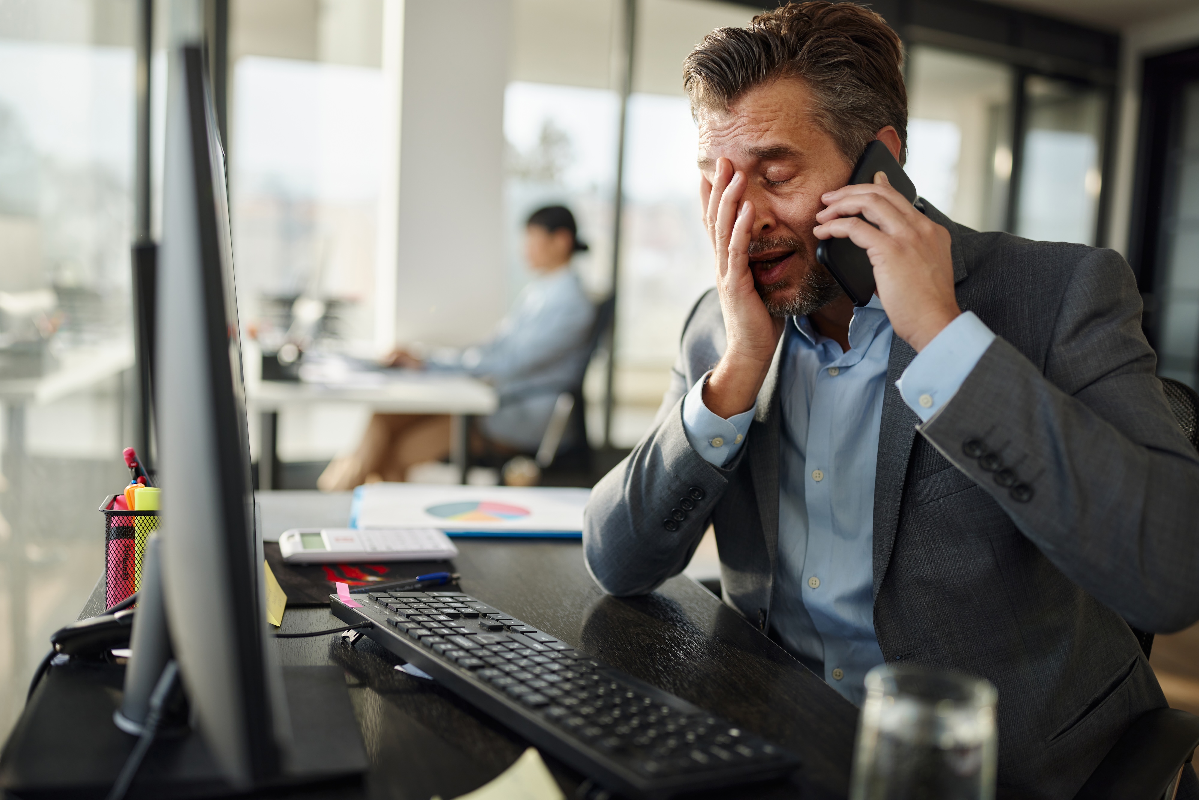 Frustrated Man On Phone And Computer