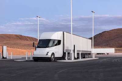 A rendering of a white Tesla Semi at a charging station.