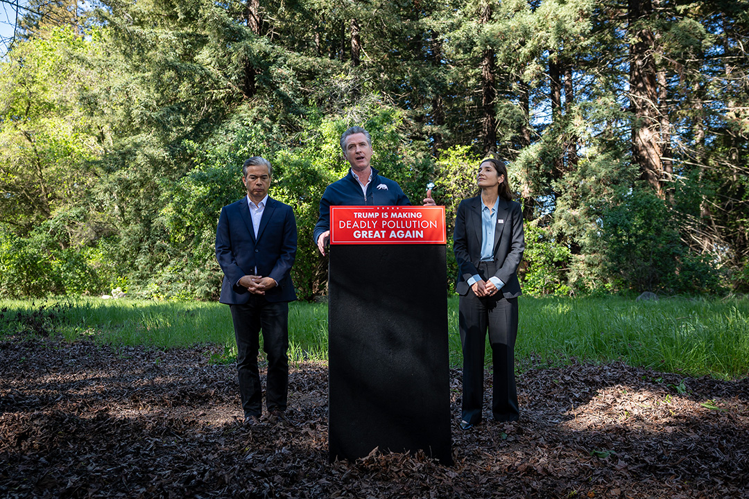 California Governor Gavin Newsom (center) announces the state's lawsuit against the Trump administration and the EPA over its repeal of the Endangerment Finding.