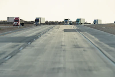 Trucks On Highway With Pavement In View