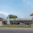 Shell gas station with fuel tanker truck delivering petrol during daytime