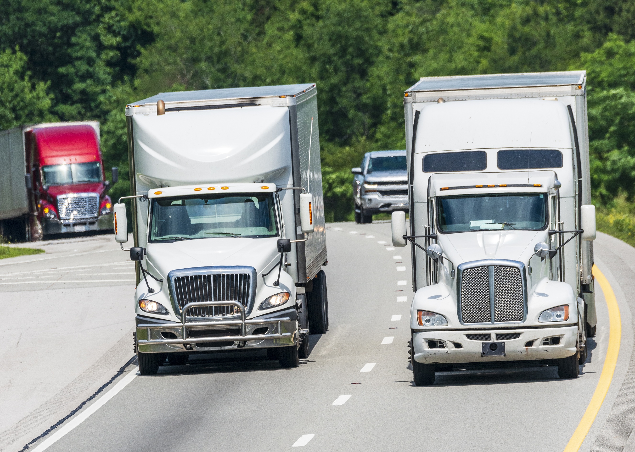 Trucks Driving Over Hill And Down Highway