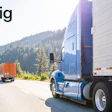 Blue semi-truck and orange delivery truck on mountain highway with forested landscape