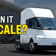 White Tesla Cybertruck electric truck displayed outdoors with industrial building and blue sky background