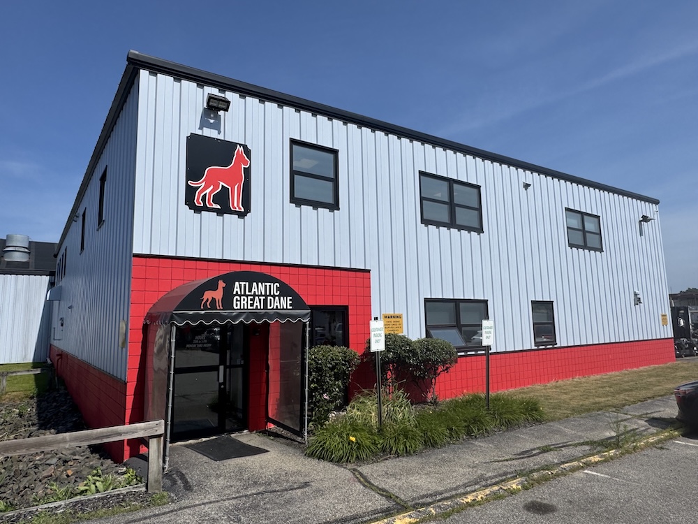 Atlantic Great Dane kennel facility with red neon dog logo and signage on white metal building exterior