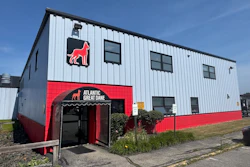 Atlantic Great Dane kennel facility with red neon dog logo and signage on white metal building exterior