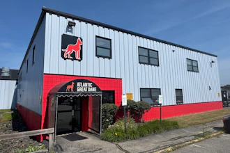 Atlantic Great Dane kennel facility with red neon dog logo and signage on white metal building exterior