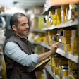 Man In Warehouse Counting Boxes