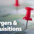 Red pushpins on a world map with 'mergers & acquisitions' text overlay representing business growth strategy