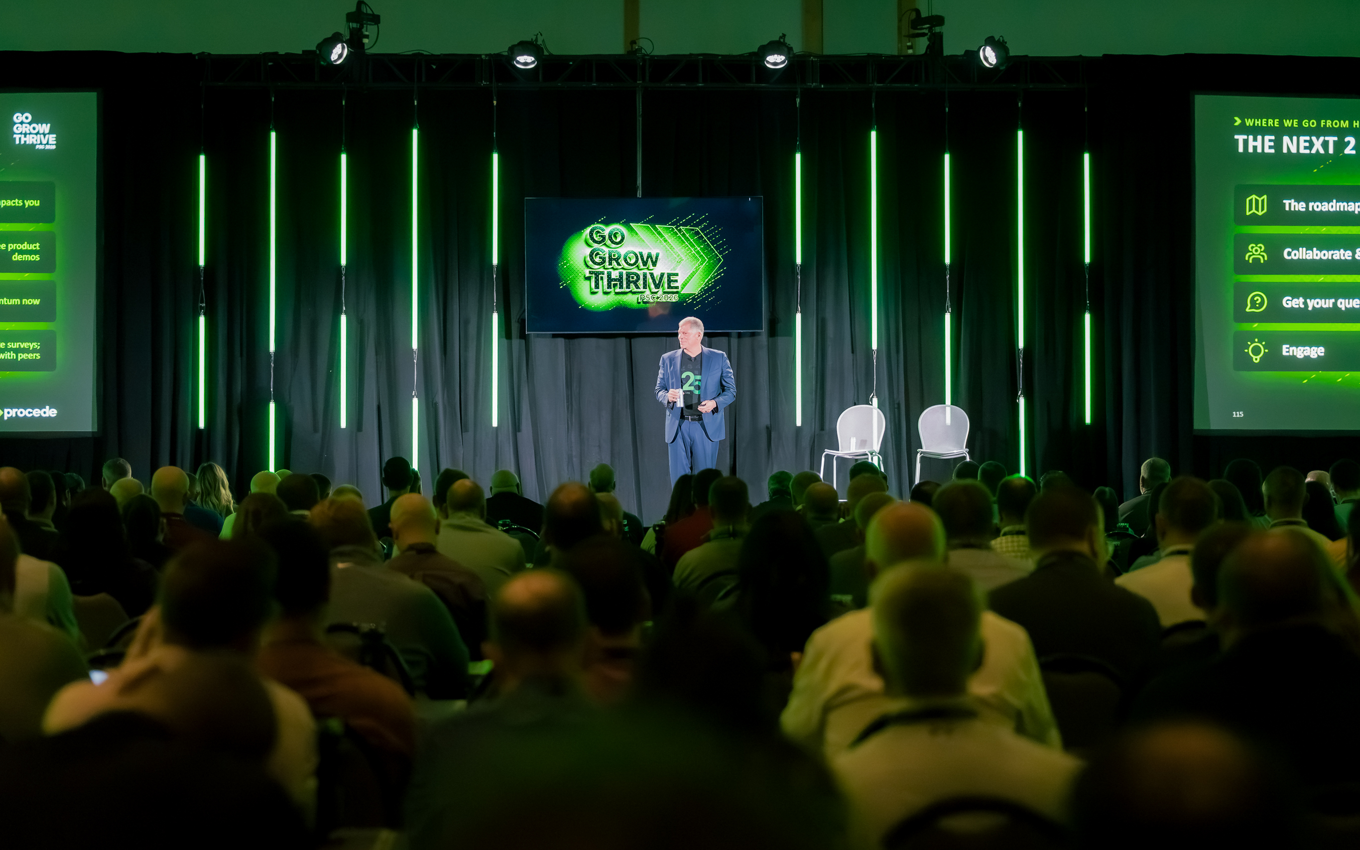 Speaker presenting at 'Go Grow Thrive' conference on stage with audience and green neon lighting