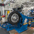 Blue ESCO tire balancing machine with mounted black tire in industrial manufacturing facility