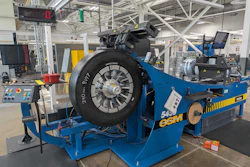 Blue ESCO tire balancing machine with mounted black tire in industrial manufacturing facility