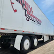 Bella Valley Transportation Solutions semi-truck trailer with red and blue branding and fuel economy tagline