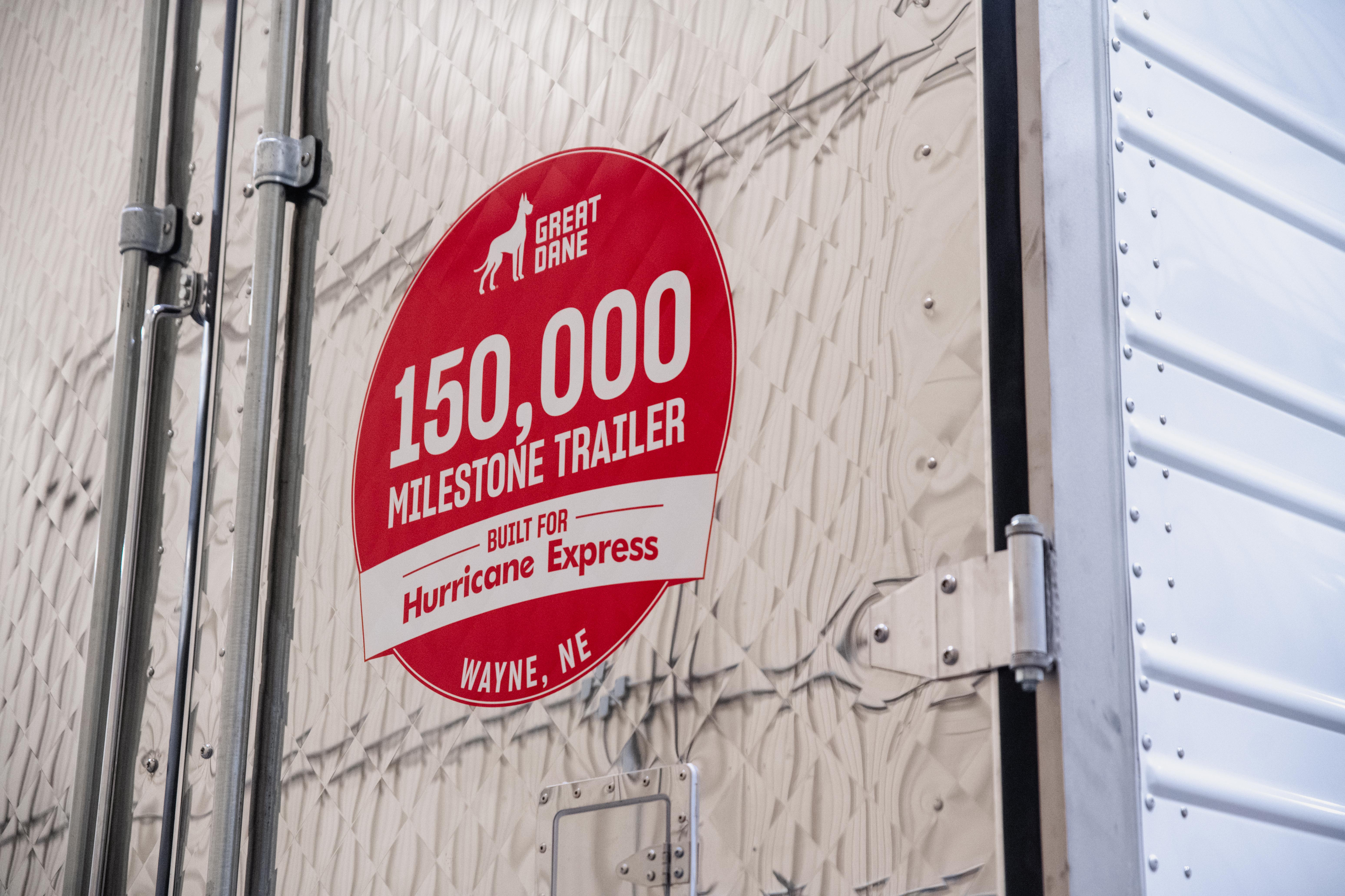 Red circular milestone badge on trailer reading '150,000 Milestone Trailer Built for Hurricane Express' from Wayne, Nebraska