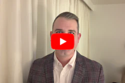 Professional man in plaid blazer with YouTube play button overlay indicating video content