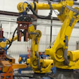 Industrial robotic arms and automated manufacturing equipment in a warehouse facility