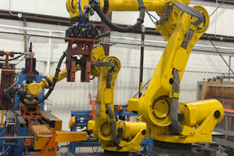 Industrial robotic arms and automated manufacturing equipment in a warehouse facility