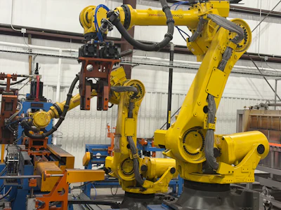 Industrial robotic arms and automated manufacturing equipment in a warehouse facility