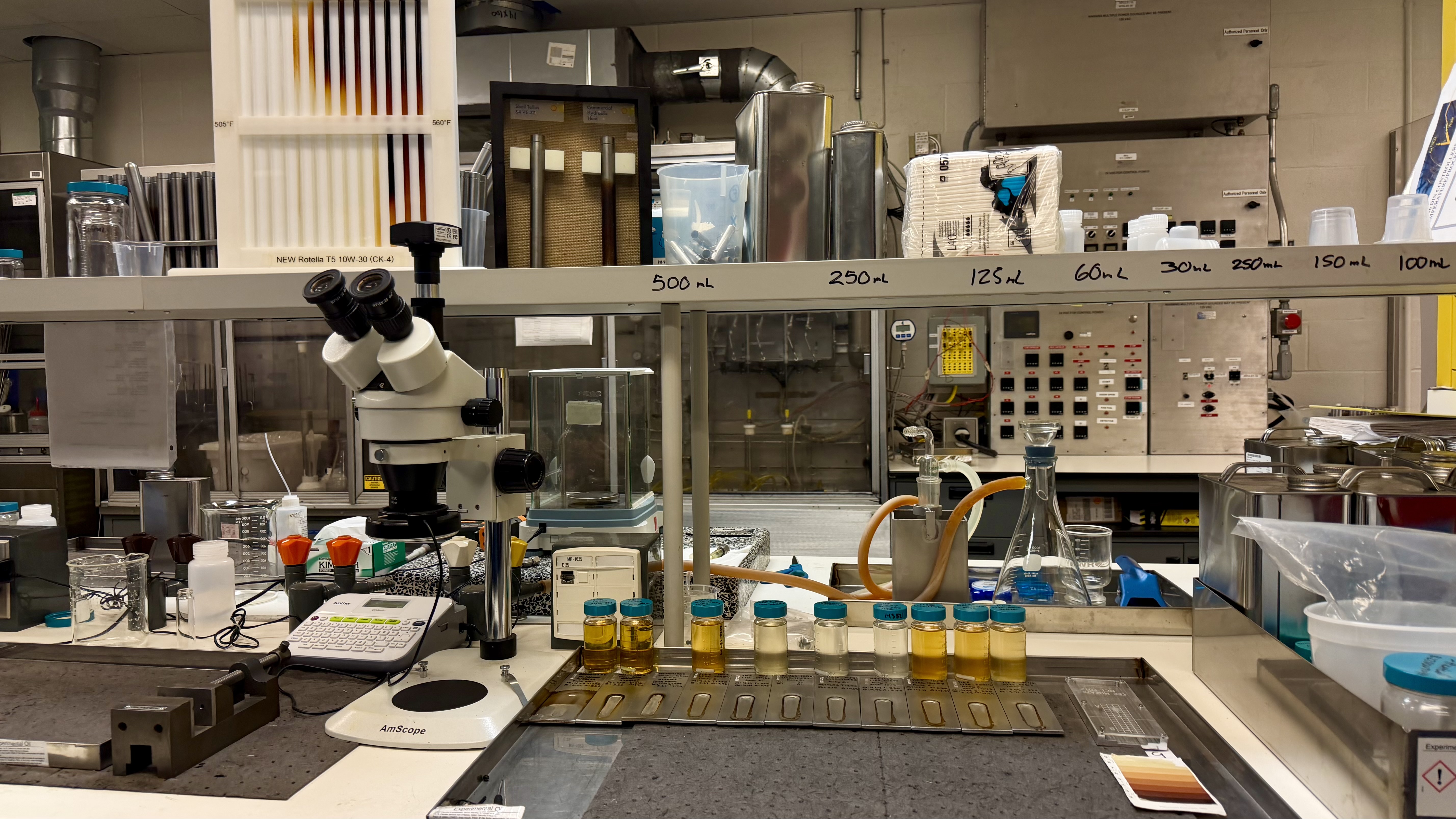 Laboratory workspace with microscope, sample trays, and scientific equipment on benches