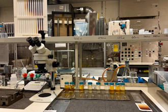 Laboratory workspace with microscope, sample trays, and scientific equipment on benches