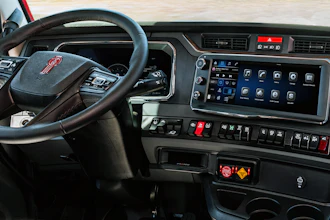 GMC truck interior dashboard with steering wheel, digital display panel, and control buttons