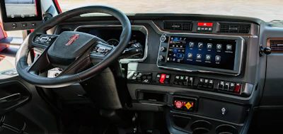 GMC truck interior dashboard with steering wheel, digital display panel, and control buttons