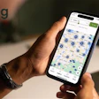 Person holding smartphone displaying RigDig map application with location markers and search interface