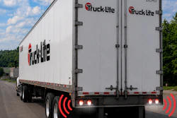 Truck Lite branded commercial delivery truck with red and white cargo box on highway