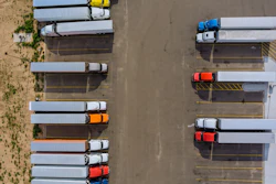 Aerial view of semi-trucks parked in organized rows at a logistics depot facility