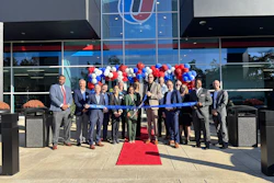 People standing in front of a building, cutting a ribbon